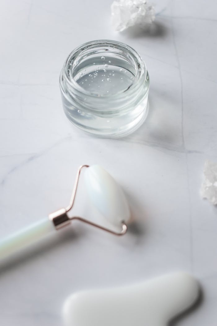 Photo of a Jade Roller Near a Glass Jar